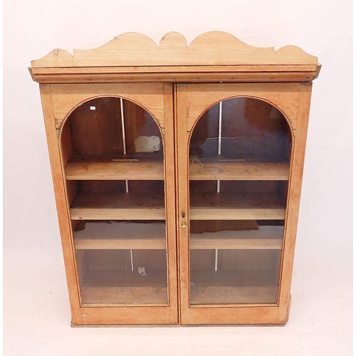 A pine two door arch glazed wall cupboard, 80cm wide x 116cm...