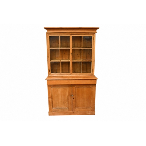 A 19th century matched two section pine bookcase cupboard. T...