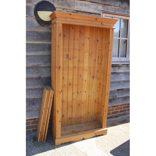 A pine open bookcase, fitted five adjustable shelves, on bra...