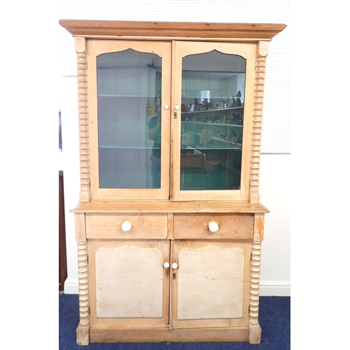 A Victorian pine glazed cabinet with two glazed doors over t...