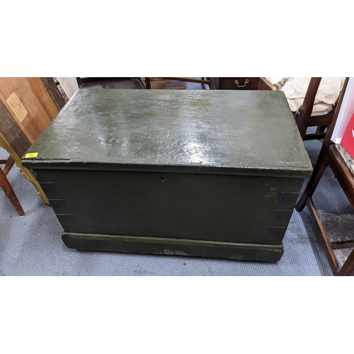 An early 20th century green painted pine chest with a hinged...
