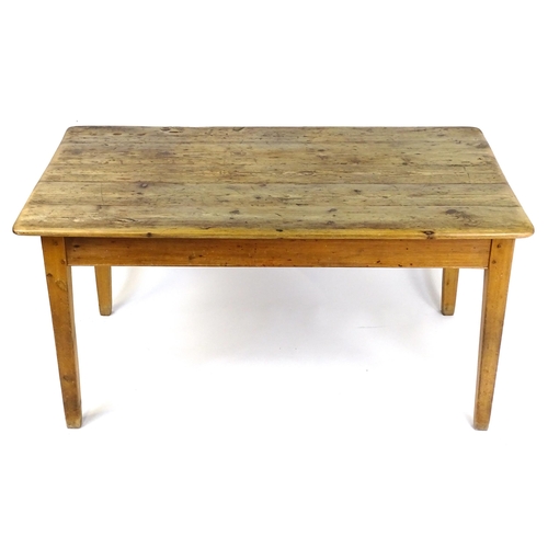 A 20thC pine kitchen / refectory table with a planked top ra...