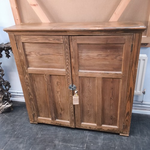 A pitch pine two door school cupboard with fitted shelves, 1...