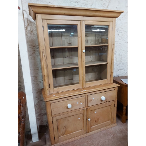 A 1.3m Victorian pine two part dresser the glazed top with m...
