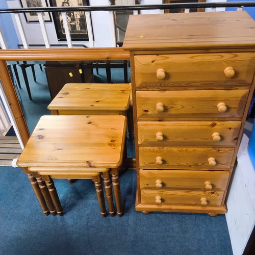A pine chest of drawers, a mirror and nest of tables