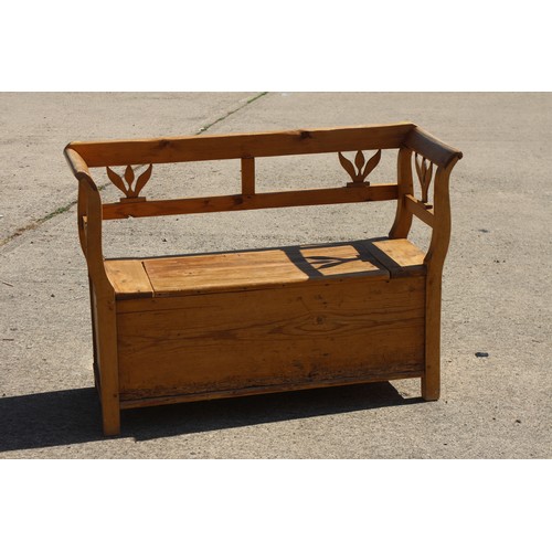 A waxed pine box seat settle with scroll arms, 51" wide x 17...