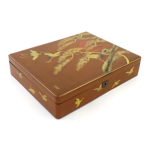 A Japanese red lacquered hinged box decorated with cranes an...