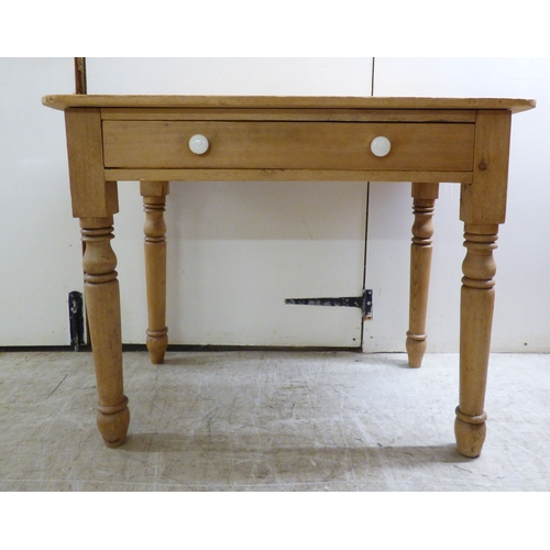 A late Victorian pine single drawer side table, raised on tu...
